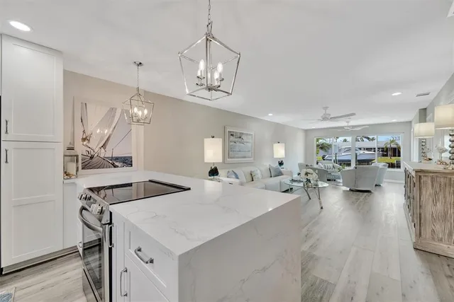 a view of a dining room and livingroom with furniture wooden floor a chandelier