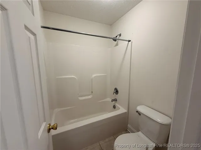 a white toilet sitting next to a bath tub
