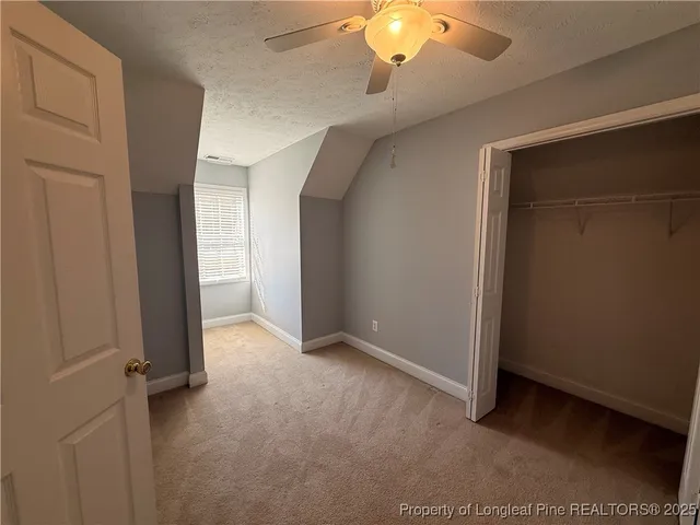 an empty room with chandelier fan