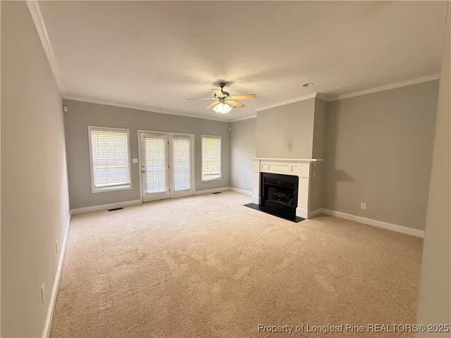an empty room with windows and fireplace