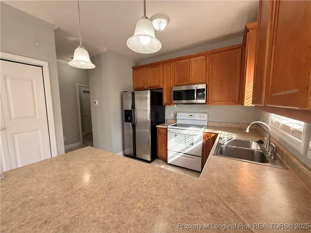 a kitchen with stainless steel appliances granite countertop a refrigerator a stove top oven a sink and dishwasher