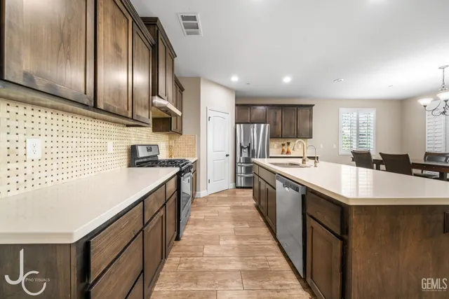 a large kitchen with stainless steel appliances lots of counter space and wooden floor