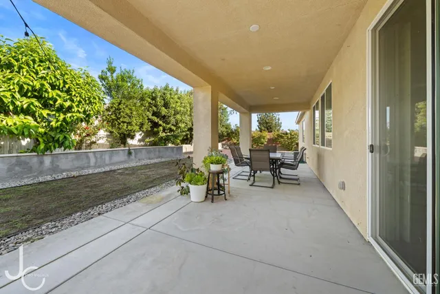 a view of a patio with table and chairs and potted plants