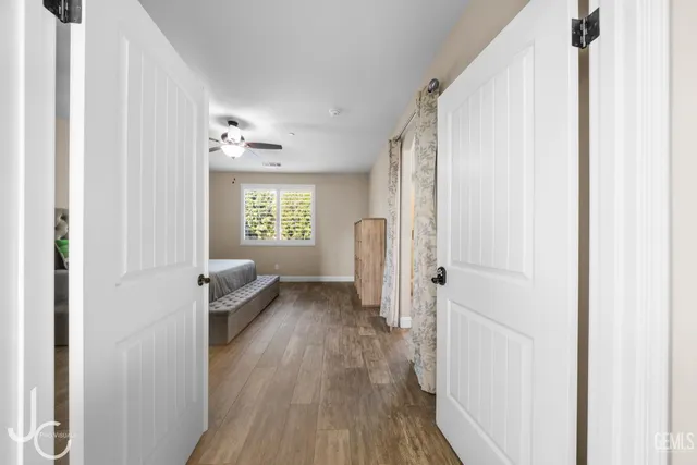 a view of a hallway with wooden floor and a living room