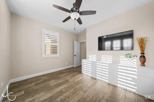 a view of a livingroom with wooden floor and a ceiling fan