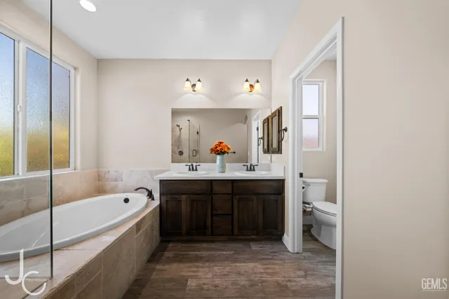 a spacious bathroom with a tub sink and mirror
