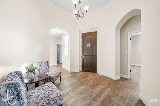 a bedroom with a bed chandelier and a window