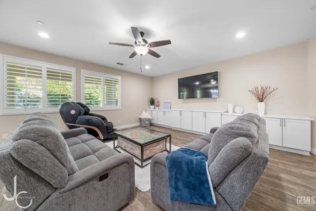 a living room with furniture ceiling fan and a flat screen tv