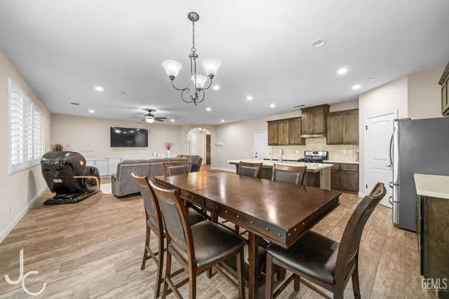 a view of a dining room and livingroom with furniture wooden floor a chandelier