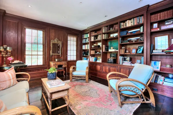 a living room with furniture a bookshelf and a large window