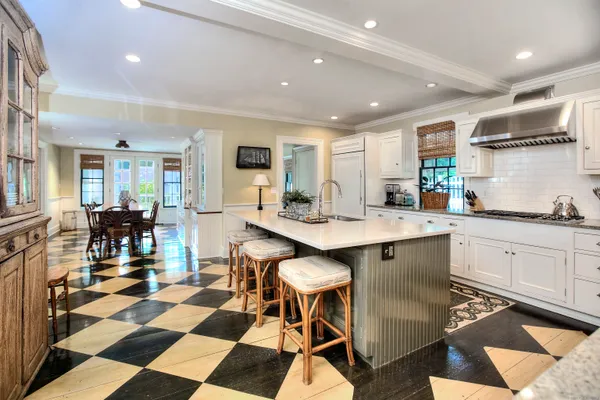 a kitchen with a dining table chairs and white cabinets