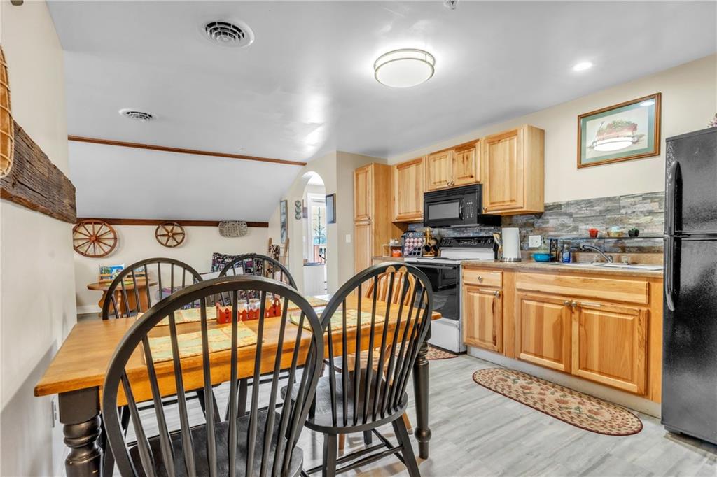 36044 Highway 66 Crown, PA 16233 - Photo 29 of 48 a very nice looking kitchen with stainless steel appliances granite countertop a stove top oven a sink a dining table and chairs with wooden floor