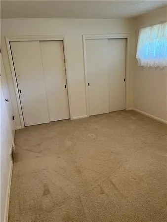 an empty room with cabinet and windows