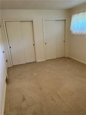 an empty room with cabinet and windows