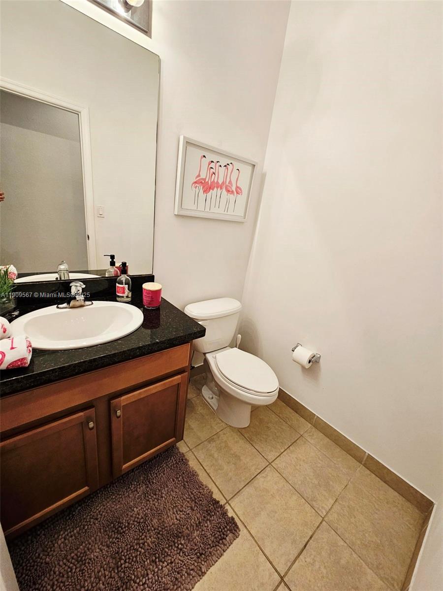 809 Southwest 147th Avenue, Unit 1401 Pembroke Pines, FL 33027 - Photo 13 of 19 a bathroom with a sink mirror vanity and toilet