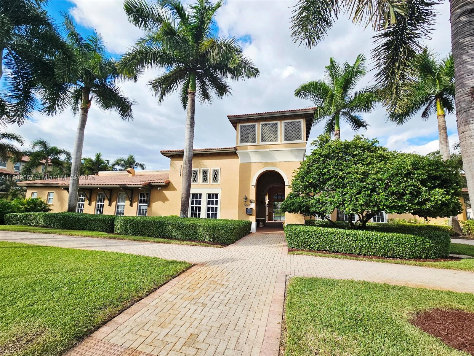 809 Southwest 147th Avenue, Unit 1401 Pembroke Pines, FL 33027 - Photo 15 of 19 a front view of a house with a garden and yard