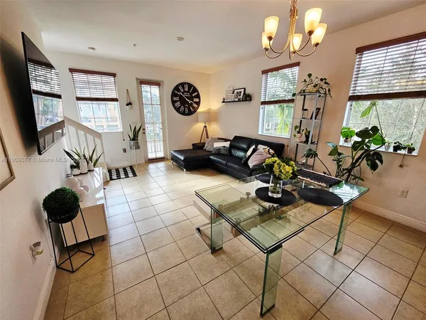 a living room with furniture a flat screen tv and a window