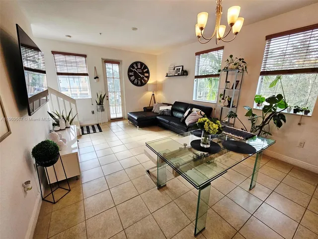 a living room with furniture a flat screen tv and a window