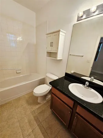 a bathroom with a granite countertop sink toilet a mirror and shower
