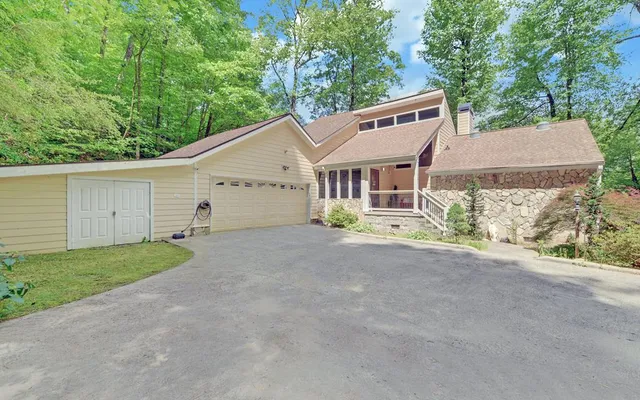 a view of a house with a yard and large tree