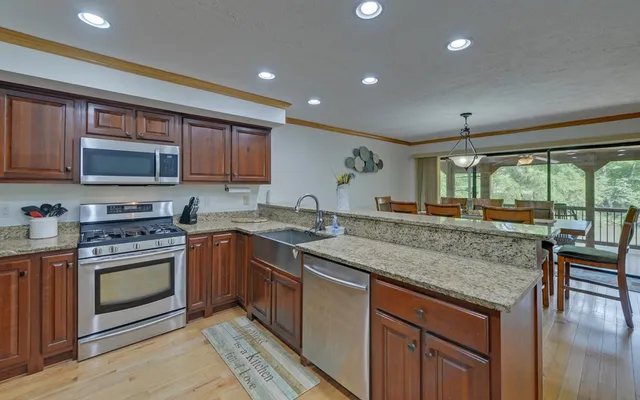 a bathroom with a granite countertop sink a mirror and a toilet