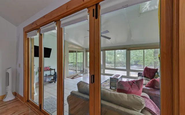 a view of a hallway with wooden floor and windows