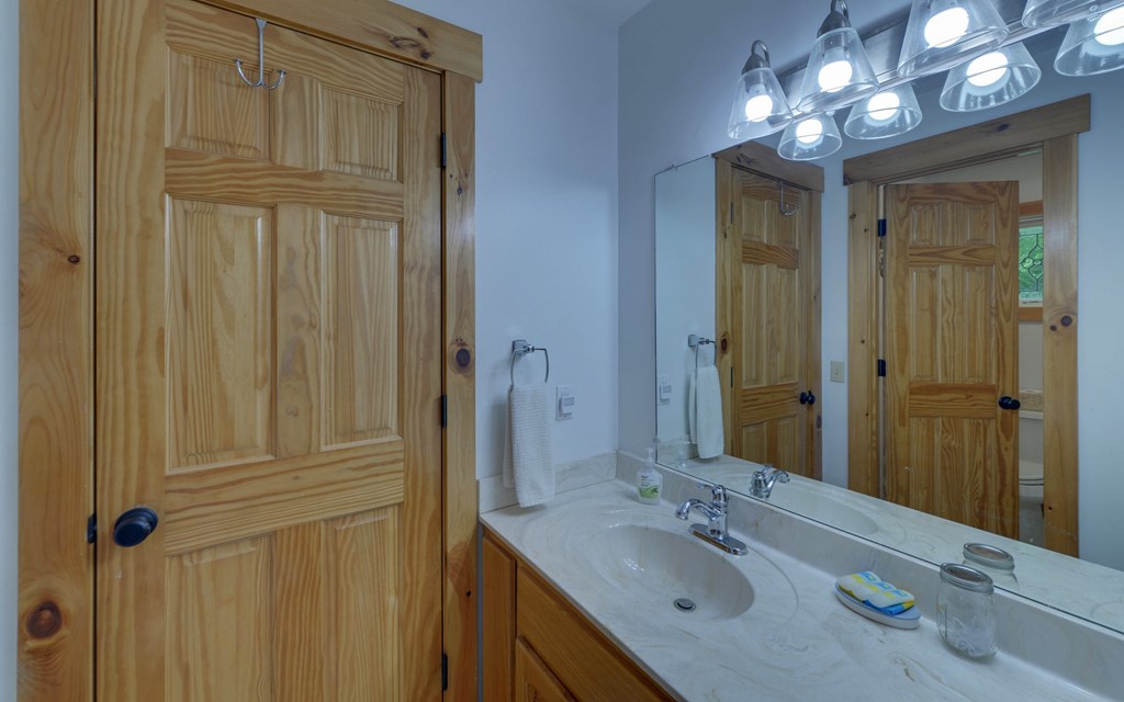321 Call-Wright Road Ellijay, GA 30540 - Photo 31 of 92 a bathroom with a granite countertop sink a light fixture and a mirror