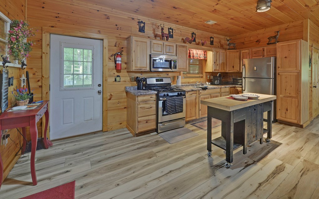 321 Call-Wright Road Ellijay, GA 30540 - Photo 56 of 92 a kitchen with kitchen island granite countertop wooden floors and stainless steel appliances
