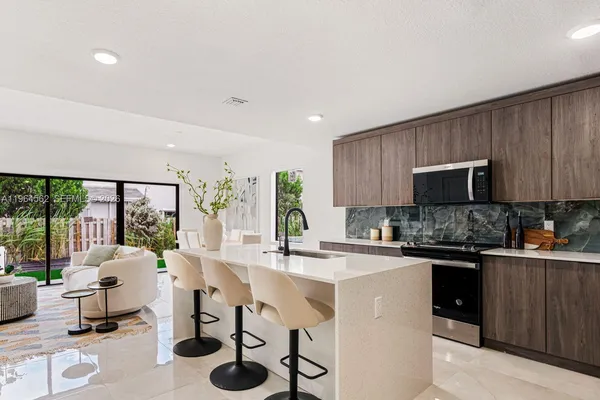 a kitchen with stainless steel appliances kitchen island granite countertop a sink and cabinets
