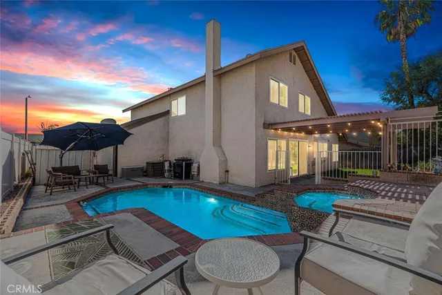 a front view of a house with swimming pool table and chairs