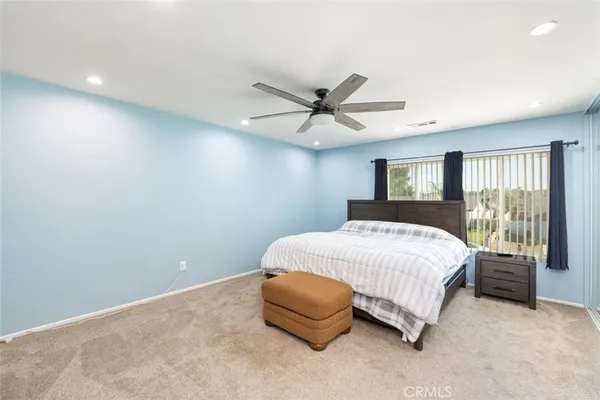 a bedroom with a large bed and a chandelier