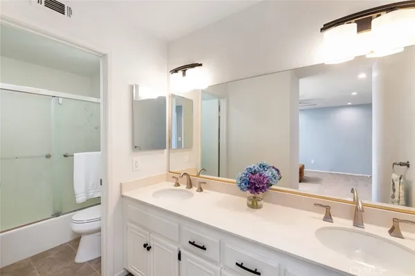 a bathroom with a sink vanity granite and toilet