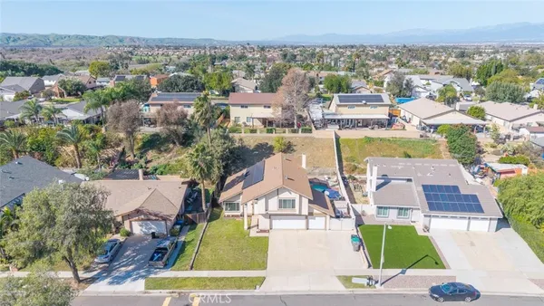 an aerial view of residential houses with outdoor space and parking