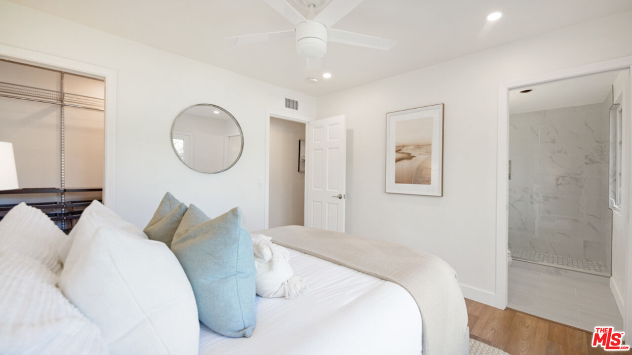 5601 Middlecoff Drive Huntington Beach, CA 92649 - Photo 17 of 49 a bedroom with a large bed and a chandelier