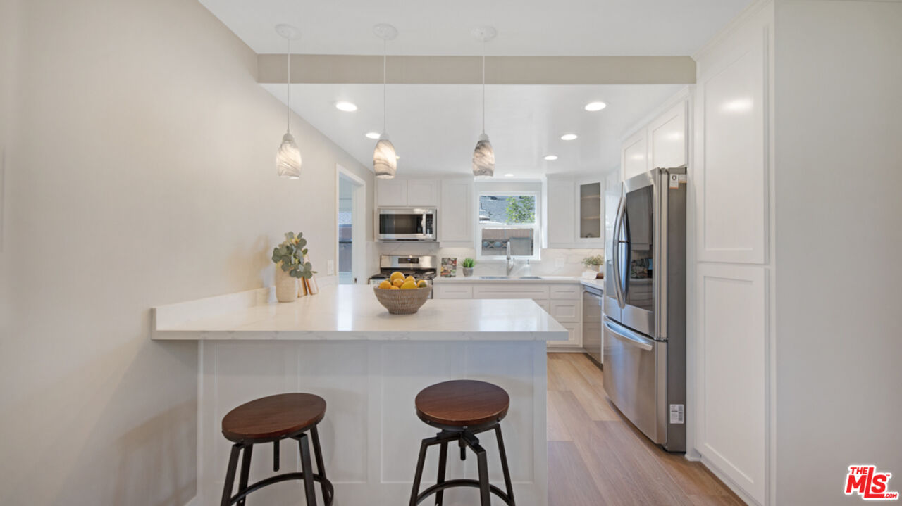 5601 Middlecoff Drive Huntington Beach, CA 92649 - Photo 27 of 49 a kitchen with stainless steel appliances granite countertop a sink refrigerator and cabinets