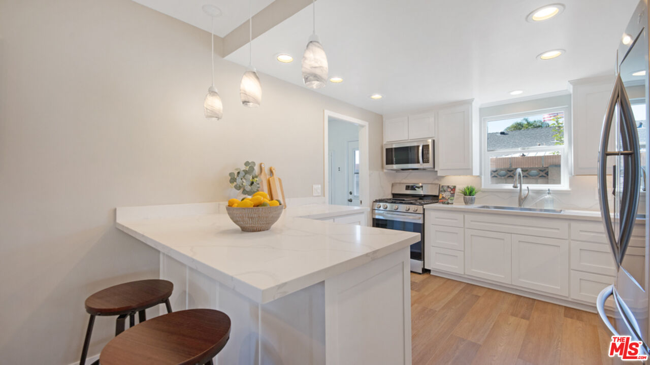 5601 Middlecoff Drive Huntington Beach, CA 92649 - Photo 28 of 49 a kitchen with a sink a stove and chairs
