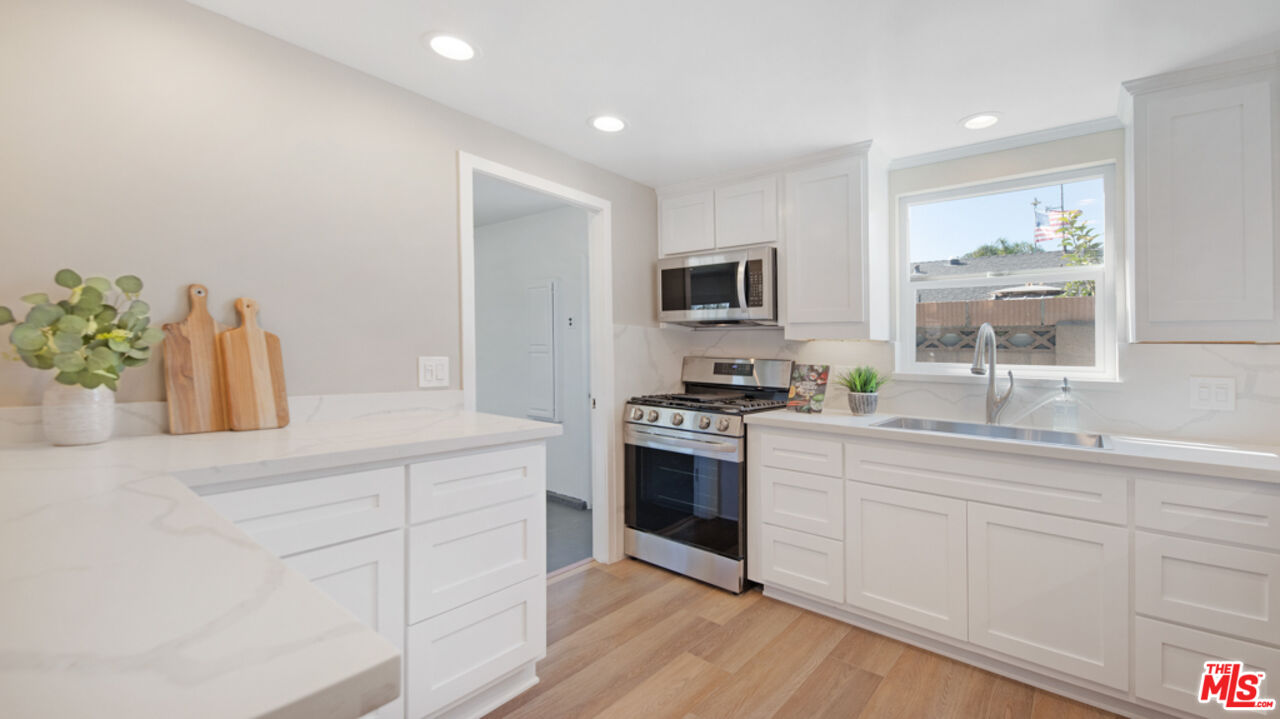 5601 Middlecoff Drive Huntington Beach, CA 92649 - Photo 29 of 49 a kitchen with white cabinets and appliances
