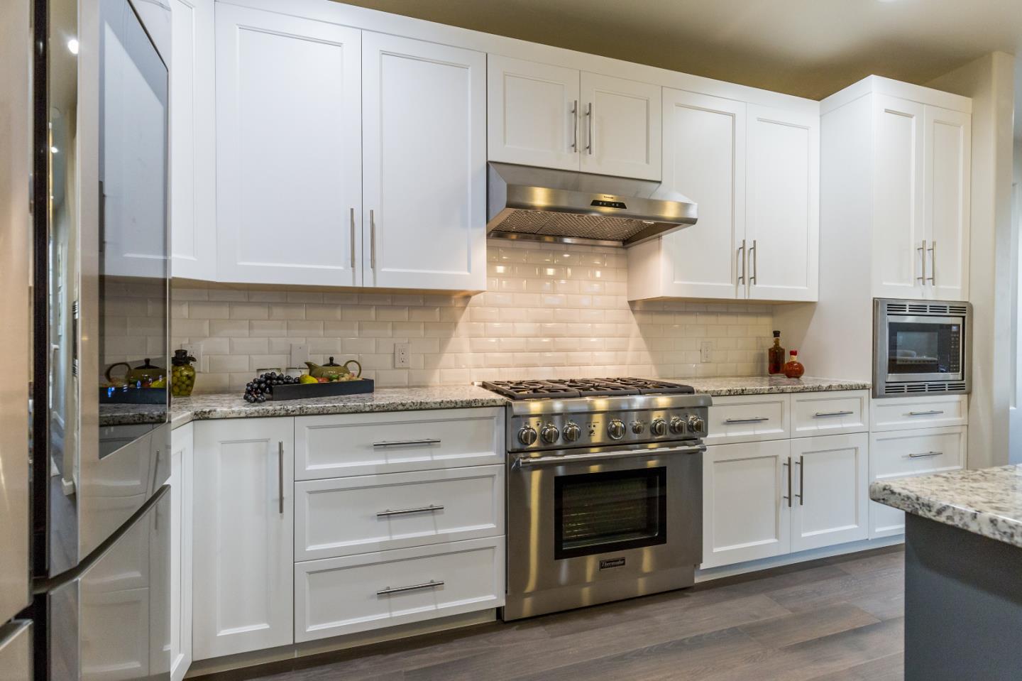 460 B Street Colma, CA 94014 - Photo 11 of 13 a kitchen with granite countertop white cabinets and stainless steel appliances