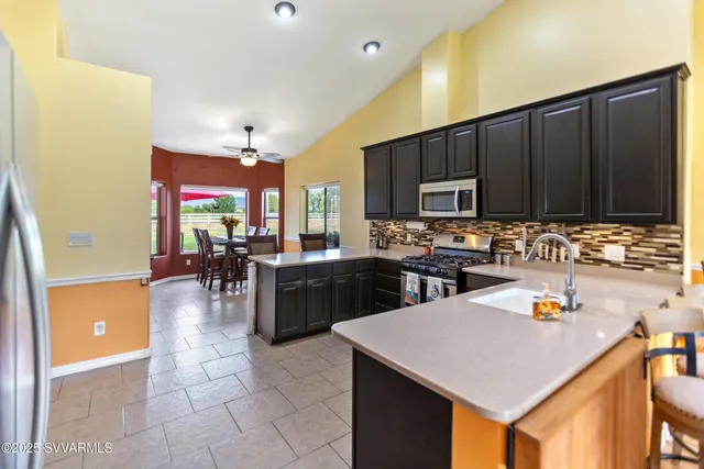 a kitchen with a sink a stove and chairs