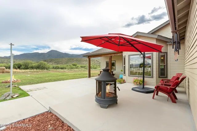 a view of pool with a table and chairs under an umbrella