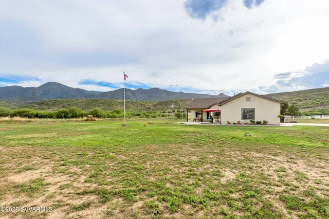 a view of an house with a garden and mountains