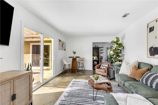 a living room with furniture a window and a flat screen tv
