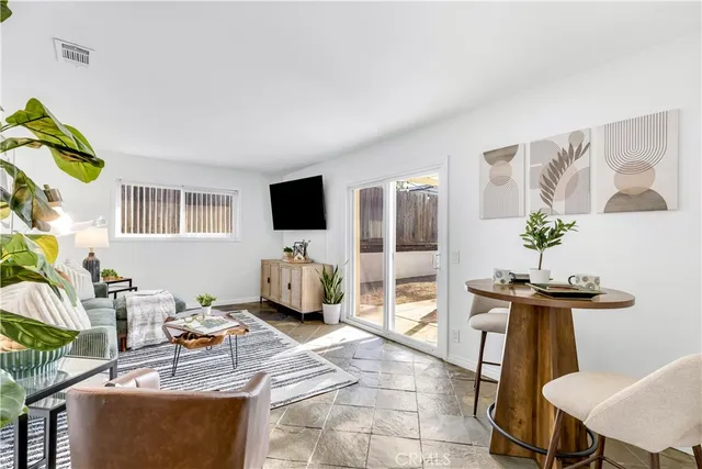 a living room with furniture a flat screen tv and a table