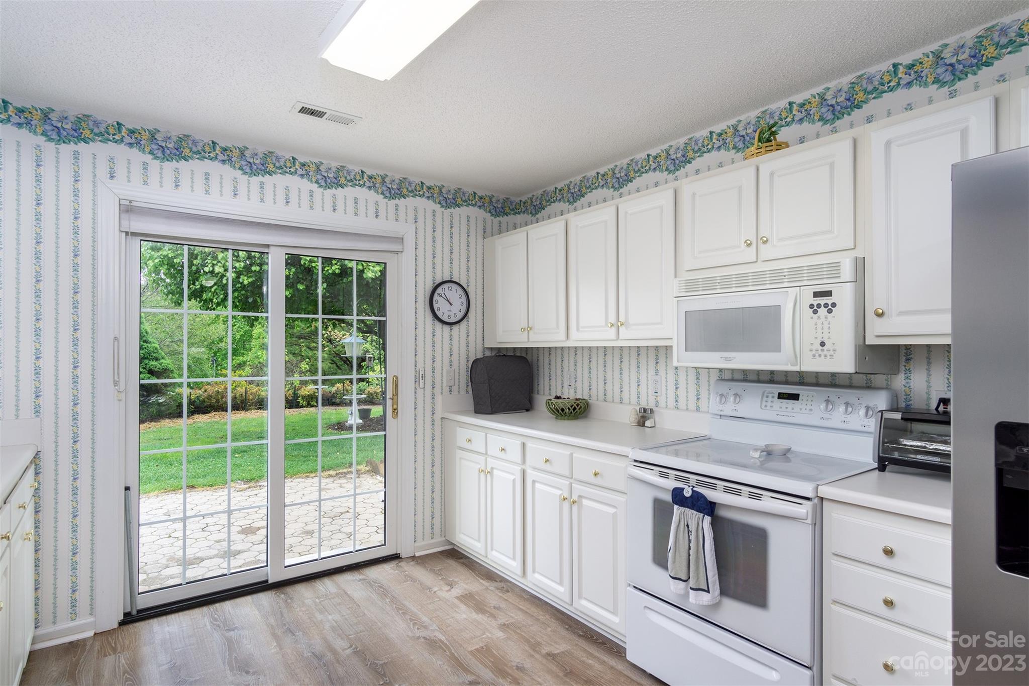 19 Briarbrook Road Fletcher, NC 28732 - Photo 28 of 46 a kitchen with stainless steel appliances granite countertop a stove a sink and white cabinets with wooden floors