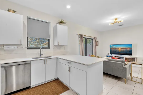 a view of kitchen with sink microwave and cabinets