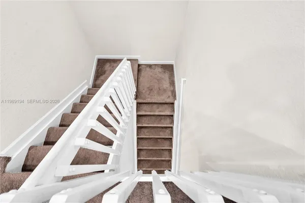 a view of staircase with white walls and a window