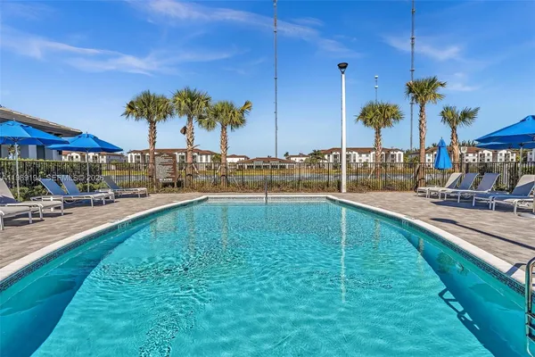 a view of a swimming pool with a lawn chairs under an umbrella