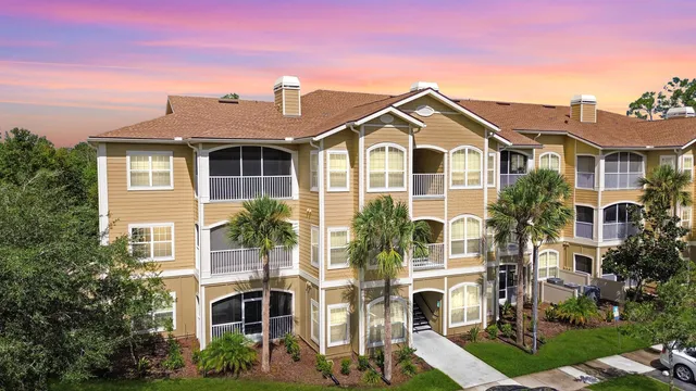 a front view of residential houses with yard and green space