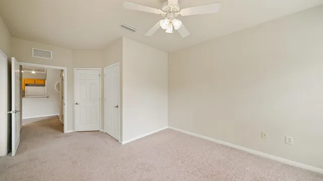 an empty room with a ceiling fan and a window