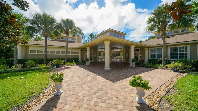 a view of a white house with a yard and potted plants